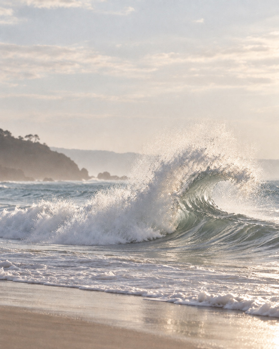 A softly lit ocean wave breaking along the shore